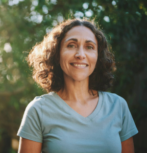 Des proches se prenant dans les bras avec des cadeaux de Noël dans les mains, ainsi qu'un sapin de Noël en arrière plan